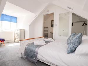 a white bedroom with a large bed and a mirror at Meneage House in Helston