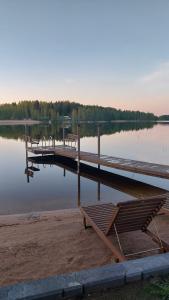 a dock with benches next to a lake at Arolahti Suite ( Rapojärvi ) in Kouvola