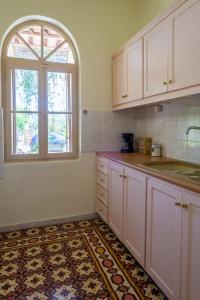 una cocina con armarios blancos y una ventana en Casa Cicala, en Pómbia