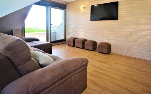 a living room with a couch and a flat screen tv at Ático de playa con vistas en Baltar - Sanxenxo in Portonovo