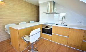 a kitchen with wooden cabinets and a sink and a stove at Ático de playa con vistas en Baltar - Sanxenxo in Portonovo