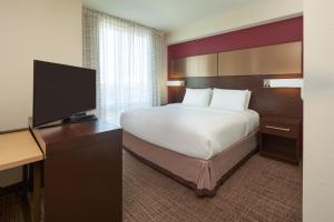 a hotel room with a bed and a flat screen tv at Residence Inn by Marriott Philadelphia Airport in Philadelphia