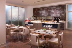 a restaurant with tables and chairs and a counter at AC Hotel by Marriott New Orleans French Quarter in New Orleans