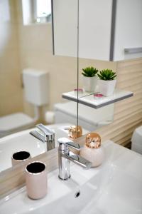 ein Badezimmer mit Waschbecken und Spiegel in der Unterkunft Family apartment Amare in Zadar + 79 Fotos