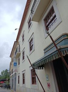 ein weißes Gebäude mit einem Kreuz auf der Seite in der Unterkunft Hotel Cavaleiros De Cristo in Tomar