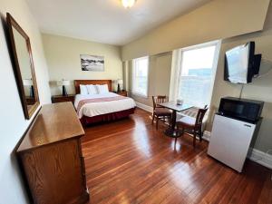 Habitación de hotel con cama y mesa con TV en Lenox Hotel and Suites, en Buffalo