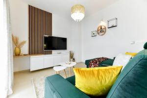 ein Wohnzimmer mit einem grünen Sofa und einem Fernseher in der Unterkunft Family apartment Amare in Zadar