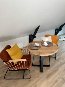 einen Tisch und zwei Stühle sowie einen Couchtisch und Stühle in der Unterkunft Tam's zolder in Boeschèpe