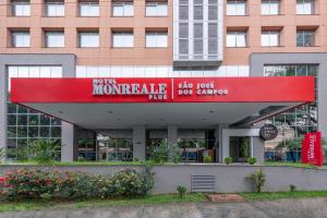 un edificio con una señal roja delante de él en Monreale Plus São José dos Campos, en São José dos Campos