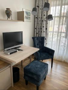 a room with a desk with a television and a chair at Hotel Gasthof Krapp in Scheßlitz