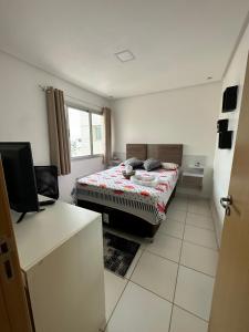 Una pequeña habitación con una cama y una ventana. en Napolitan Paradise Apartamento Dom Pedro Manaus, en Manaus