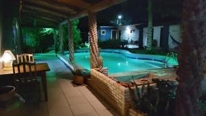 a swimming pool at night with a resort at Pousada La Luna in Paracuru