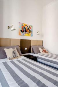 a room with two beds and a painting on the wall at Francesco Romestay - Termini in Rome