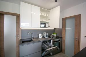 a kitchen with white cabinets and a sink at Holiday house Oljka in Kobdilj
