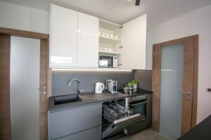 KobdiljにあるHoliday house Oljkaの白いキャビネットとシンクのあるキッチン