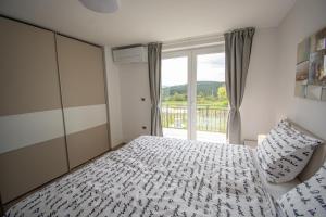 KobdiljにあるHoliday house Oljkaのベッドと大きな窓のある寝室 +6枚の写真