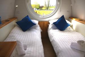 2 camas en una habitación pequeña con ventana en Armadilla 3 at Lee Wick Farm Cottages & Glamping en Clacton-on-Sea