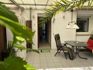 a patio with a table and chairs and a couch at Home-Rose-Garden-Gästehaus kontaktloser Zugang in Düsseldorf