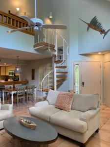 a living room with a couch and a spiral staircase at Gated Gulf Front Condo in Hidden Dunes Beach & Tennis Resort in Destin