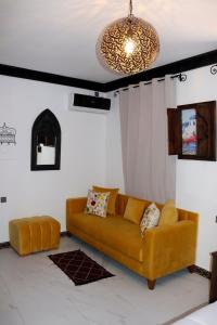 sala de estar con sofá y lámpara de araña en Riad El Palacio & Spa Chaouen, en Chefchaouen