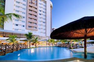 een groot hotel met een zwembad voor een gebouw bij Suites Le Jardin - Caldas Novas in Caldas Novas