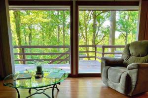 a living room with a glass table and a chair at Modern Cabin With Hot Tub Grill Lake Beach Wineries Hiking Fishing And Hershey Park Family And Pet Friendly Superhosts On AB&B in Mount Gretna