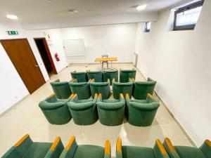 une salle de réunion avec des chaises vertes et une table dans l'établissement HI Areia Branca - Pousada de Juventude, à Areia Branca