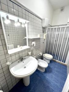 Hotel Minerva في أوترانتو: حمام مع حوض أبيض ومرحاض