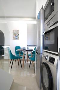 a kitchen with a washing machine and a table with chairs at Ocean Boulevard Tenerife in San Miguel de Abona