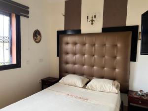 a bedroom with a large bed with a large headboard at Dar laabi in Marrakesh