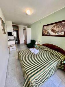 a bedroom with a large bed with a striped blanket at Hotel Minerva in Otranto