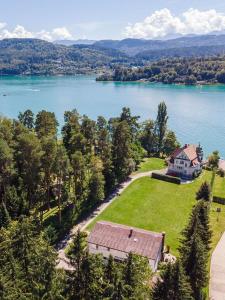 an aerial view of a house on a lawn next to a lake at Seeappartements Eden in Pörtschach am Wörthersee