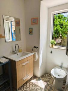 a bathroom with a sink and a toilet and a window at Cozy 3 BR Home - Close to Beach in Lourinhã