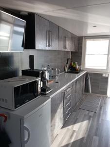 a kitchen with a microwave on top of a counter at Koncér úszóház in Abádszalók