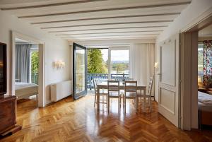 a dining room with a table and chairs and a balcony at Seeappartements Eden in Pörtschach am Wörthersee