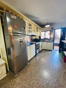 uma cozinha com um frigorífico de aço inoxidável e armários em Carlos Paz Hostel&Suites em Villa Carlos Paz