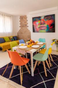 ein Wohnzimmer mit einem Tisch und bunten Stühlen in der Unterkunft Grand Villa in Valencia