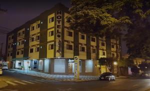 ein gelbes Gebäude mit einem davor geparkt in der Unterkunft ROMA'S HOTEL in Umuarama