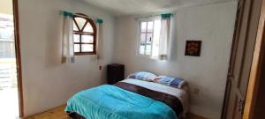 a small bedroom with a bed and a window at Cabaña Papá Beto in Mineral del Monte