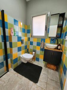 ein farbenfrohes Bad mit WC und Waschbecken in der Unterkunft The house of love in Meitar