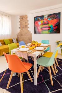 ein Esszimmer mit einem Tisch und bunten Stühlen in der Unterkunft Grand Villa in Valencia