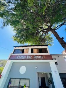 um edifício com uma árvore em cima dele em Carlos Paz Hostel&Suites em Villa Carlos Paz