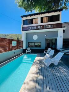 una casa con piscina al lado de un edificio en Carlos Paz Hostel&Suites en Villa Carlos Paz