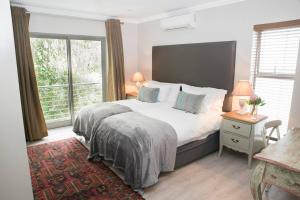 a bedroom with a bed and a large window at 13 La Gratitude Luxury Apartment-with backup power for loadshedding in Stellenbosch