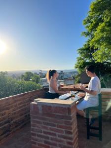 un hombre y una mujer sentados en una mesa en Carlos Paz Hostel&Suites en Villa Carlos Paz