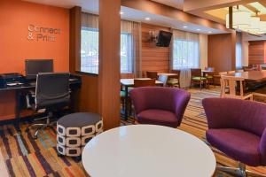 une salle d'attente avec une table blanche et des chaises violettes dans l'établissement Fairfield Inn Jacksonville Orange Park, à Orange Park