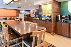 a restaurant with a large wooden table and chairs at Fairfield Inn Jacksonville Orange Park in Orange Park