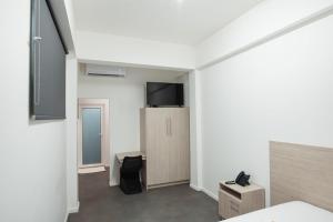 a room with a bed and a tv on a wall at Hotel Royal Brasil in Paramaribo
