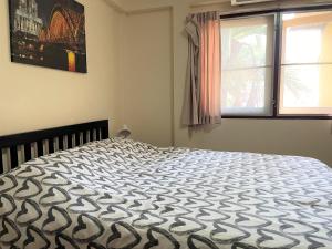 1 dormitorio con 1 cama grande en una habitación con ventana en Taphouse, en Hua Hin