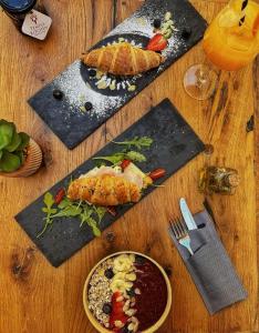 einem Holztisch mit Teller mit Lebensmitteln und einem Teller mit Lebensmitteln in der Unterkunft Luxury B&B Rooms Matusko in Split